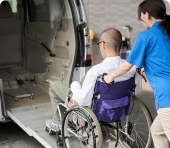 woman helping her patient on wheelchair in boarding a van