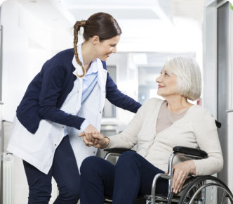 woman holding her patients hand sitting on wheelchair